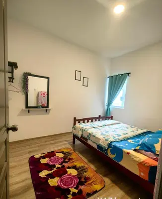 a bedroom with a bed and a mirror and a rug at KAZ homestay in Tanah Rata