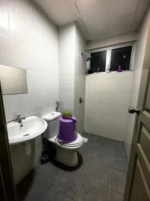 a bathroom with a toilet with a purple pot on it at KAZ homestay in Tanah Rata
