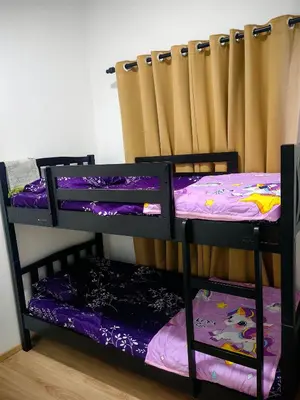 two bunk beds in a room with a curtain at KAZ homestay in Tanah Rata