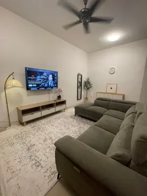 a living room with a couch and a flat screen tv at Orked Homestay 2 Parit Buntar in Parit Buntar