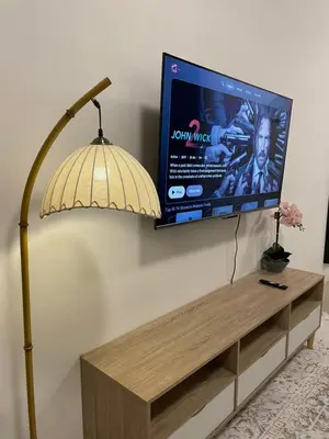 a flat screen tv on a wall next to a lamp at Orked Homestay 2 Parit Buntar in Parit Buntar