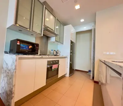 a kitchen with white cabinets and a microwave at Straits Quay Seaview in Tanjung Bungah
