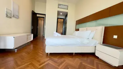 a bedroom with a large white bed and wooden floors at Straits Quay Seaview in Tanjung Bungah