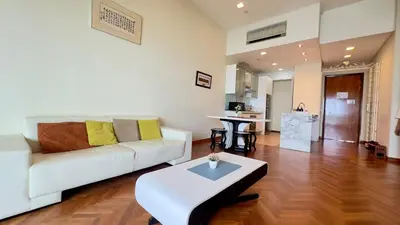 a living room with a white couch and a table at Straits Quay Seaview in Tanjung Bungah
