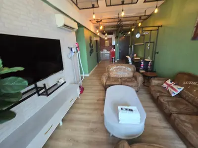 a living room with a couch and a flat screen tv at The Majestic Privilege Suites - Ipoh in Ipoh