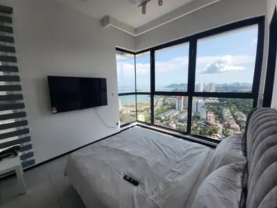 a bedroom with a bed and a flat screen tv at Urban Suite the Privilege Suites by Merveille in George Town