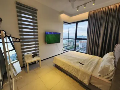 a bedroom with a bed and a flat screen tv at Urban Suite the Privilege Suites by Merveille in George Town