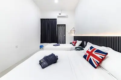 two beds in a room with white walls at i Homes Villa 3 Nearby Sunway - Swimming Pool and Karaoke in Ipoh