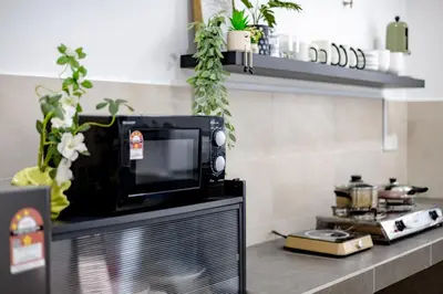 a microwave sitting on top of a counter in a kitchen at i Homes Villa 3 Nearby Sunway - Swimming Pool and Karaoke in Ipoh