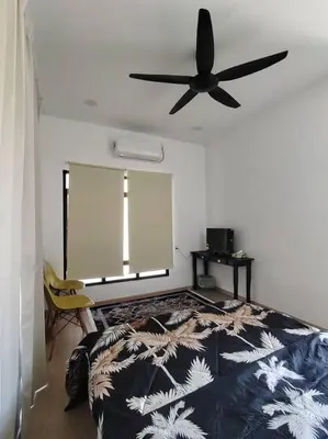 a bedroom with a bed and a ceiling fan at Desa Damai Homestay in Penaga