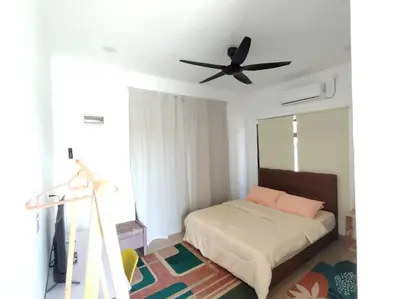 a bedroom with a bed with a ceiling fan at Desa Damai Homestay in Penaga