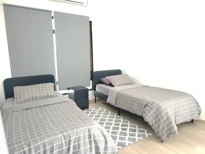 a bedroom with two beds and a couch at Desa Damai Homestay in Penaga