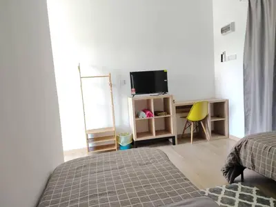 a bedroom with a bed and a desk with a television at Desa Damai Homestay in Penaga