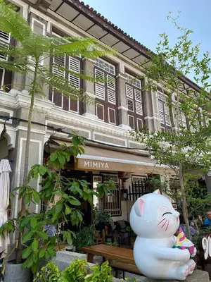 a white cat statue sitting in front of a building at Easy Access to Airport, USM & Queensbay in Bayan Lepas
