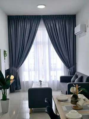 a living room with a large window with blue curtains at d05 The Anderson Ipoh Family Stay 2BR in Ipoh