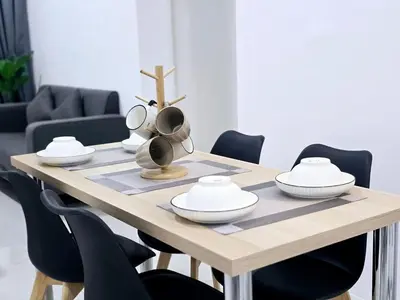 a wooden table with bowls and plates on it at d05 The Anderson Ipoh Family Stay 2BR in Ipoh