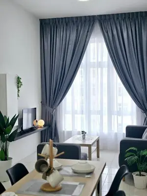 a living room with blue curtains and a table at d05 The Anderson Ipoh Family Stay 2BR in Ipoh