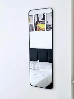 a mirror reflecting a bed and a yellow car at c06 The Anderson Ipoh Family Stay 2BR in Ipoh