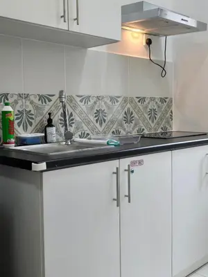 a kitchen with white cabinets and a sink at b07 The Anderson Ipoh Family Stay 2BR in Ipoh