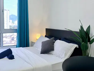 a bedroom with a bed with pillows and a plant at b07 The Anderson Ipoh Family Stay 2BR in Ipoh