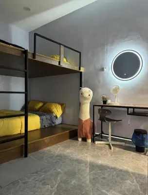 a bedroom with two bunk beds and a desk and a teddy bear at TY Youth Hostel in Sekincan