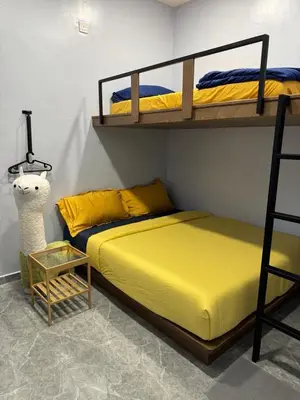 a bedroom with two bunk beds and a table at TY Youth Hostel in Sekincan