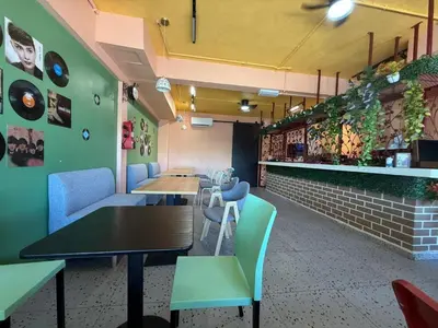 a restaurant with tables and chairs and a bar at TY Youth Hostel in Sekincan