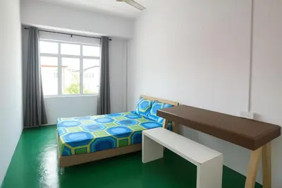 a bedroom with a bed and a desk and a window at TK Homie in Tanjung Karang