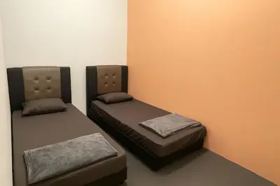 two beds sitting next to each other in a room at TK Homie in Tanjung Karang