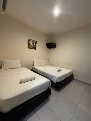 two beds sitting next to each other in a room at JJ Hotel Sitiawan Perak in Sitiawan