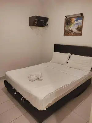 a bed in a room with a white bedvisor at JJ Hotel Sitiawan Perak in Sitiawan