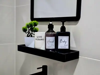 a bathroom shelf with two bottles of soap and a mirror at b04 The Anderson Ipoh Family Stay 2BR in Ipoh