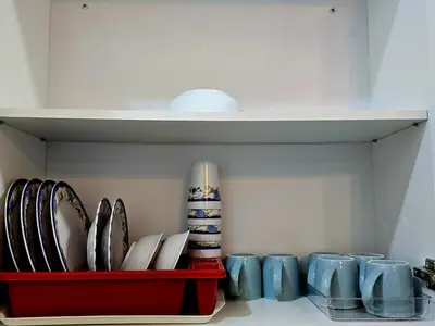 a shelf with plates and mugs in a kitchen at b04 The Anderson Ipoh Family Stay 2BR in Ipoh