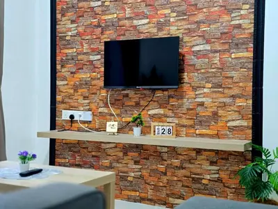 a tv on a brick wall with a tv on it at c04 The Anderson Ipoh Family Stay 2BR in Ipoh