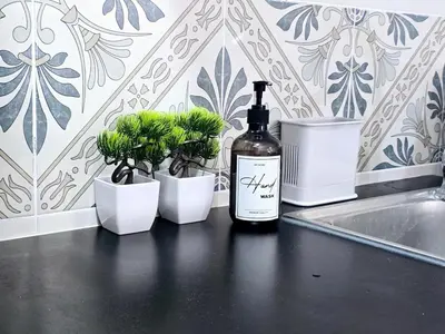 a bottle of wine sitting on a counter next to potted plants at c04 The Anderson Ipoh Family Stay 2BR in Ipoh