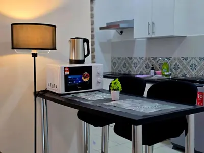a table with a computer and a lamp on it at d02 The Anderson Ipoh Family Stay 2BR in Ipoh
