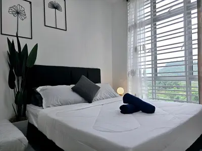 a large white bed with a blue pillow on it at b03 The Anderson Ipoh Family Stay 2BR in Ipoh