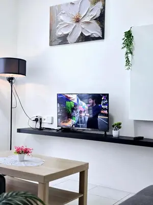 a living room with a tv on a wall at b03 The Anderson Ipoh Family Stay 2BR in Ipoh