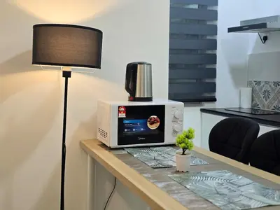 a table with a microwave and a lamp on it at b06 The Anderson Ipoh Family Stay 2BR in Ipoh