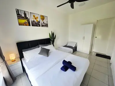 a bedroom with a large white bed with blue crosses on it at d15 The Anderson Ipoh Family Stay 2BR in Ipoh