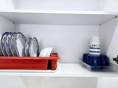 a shelf with plates and utensils in a kitchen at d15 The Anderson Ipoh Family Stay 2BR in Ipoh