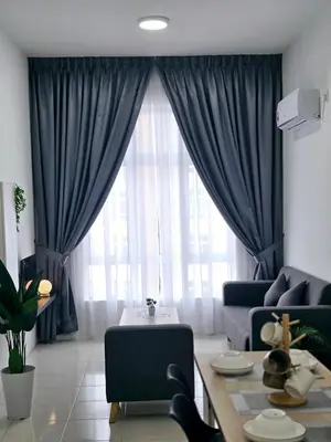 a living room with blue curtains and a couch at b05 The Anderson Ipoh Family Stay 2BR in Ipoh