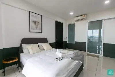 a bedroom with a large white bed and a window at Jomstay Octagon Ipoh Penthouse in Ipoh
