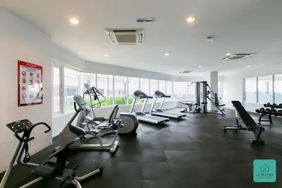 a gym with several treadmills and cardio machines at Jomstay Octagon Ipoh Penthouse in Ipoh