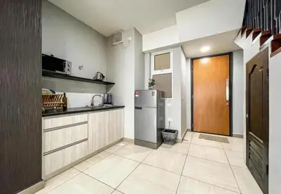 a large kitchen with a refrigerator and a door at Jomstay Octagon Ipoh Penthouse in Ipoh