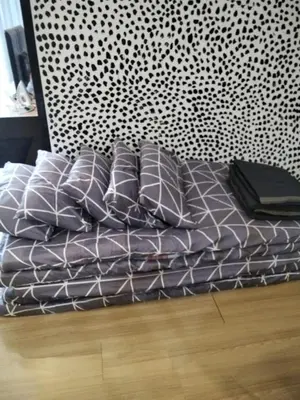 a bed with purple and white pillows on it at AYAAN SOCCER HOME at Quintet Apartment with Free Parking in Tanah Rata