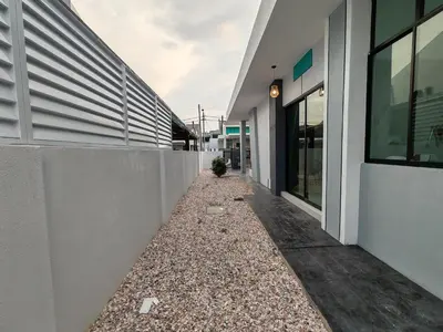 a walkway between two buildings with a plant in the middle at Starhill Lake Retreat in Lahat