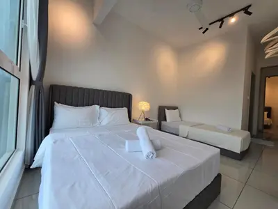 a bedroom with a large white bed and a chair at ICC Premium Executive Suite - Ipoh in Ipoh