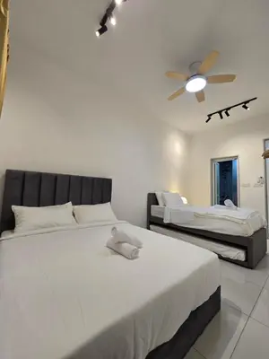 a bedroom with two beds and a ceiling fan at ICC Ipoh Bond Suites by Merveille Louise in Ipoh