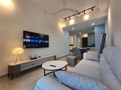 a living room with a couch and a tv on the wall at ICC Ipoh Bond Suites by Merveille Louise in Ipoh